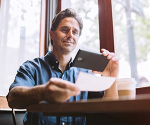 man taking a picture of a check