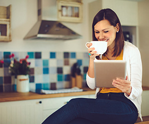 woman on tablet with mug