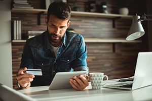 man on tablet with credit card