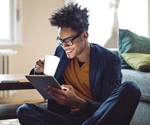 man smiling and looking at tablet