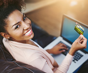 woman on computer holding up card