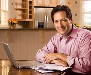 man sitting with computer and smiling