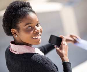 woman with phone smiling at camera