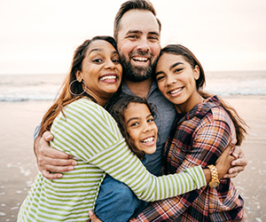 family hugging on beach